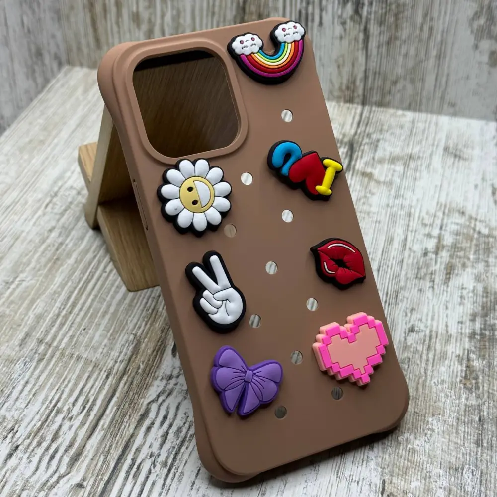 Коричневий Crocs-чохол для iPhone з емодзі: веселка, квітка, сердечко, знак миру та бантик